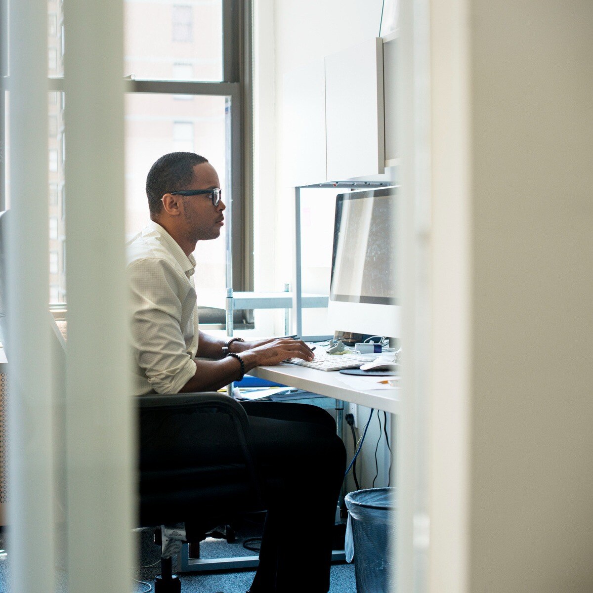 a-man-working-in-an-office-seated-at-a-desk-looki-2023-11-27-05-34-31-utc-1